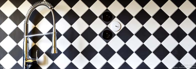 dans le bloc technique avec la cuisine et la salle de bain, crédence moderne de carreau en damier avec un mitigeur Duravit