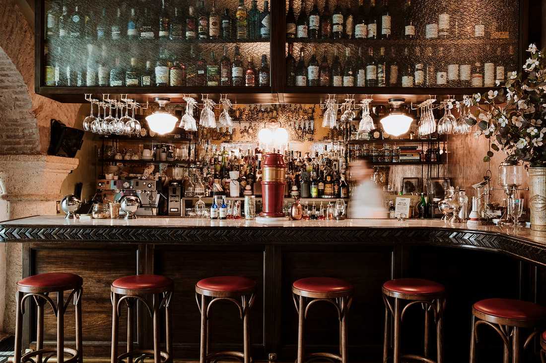 Aménagement d'un restaurant bistrot et tropical -  tabourets autour du bar